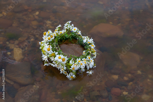 Photo: Beautiful wreath with summer flowers in the water. Beautiful wreath with summer flowers in the water.