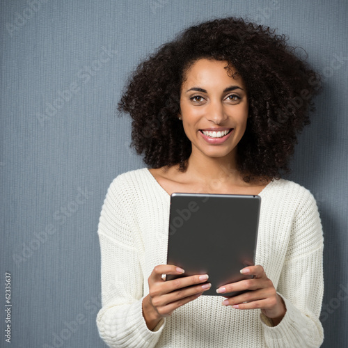 Photo: frau mit locken hält tablet in der hand frau mit locken hält tablet in der hand