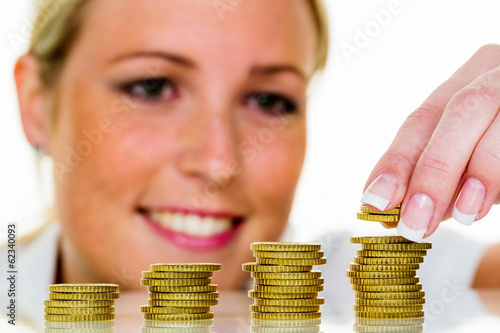 Photo: Frau mit Münzstapel beim Geld sparen Frau mit Münzstapel beim Geld sparen