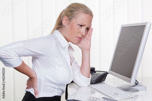Photo: Frau mit Rückenschmerzen im Büro Frau mit Rückenschmerzen im Büro