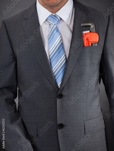 Photo: Businessman In Suit With Adjustable Wrench In Pocket Businessman In Suit With Adjustable Wrench In Pocket