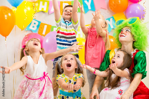 Photo: children group with clown celebrating birthday party children group with clown celebrating birthday party