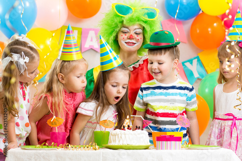 Photo: kids blowing candle on festive cake kids blowing candle on festive cake