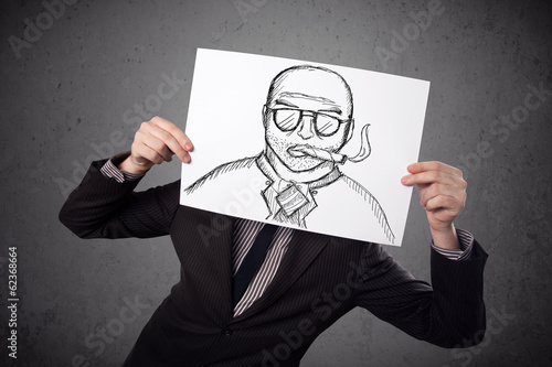 Photo: Businessman holding a cardboard with a smoking man on it in fron Businessman holding a cardboard with a smoking man on it in fron