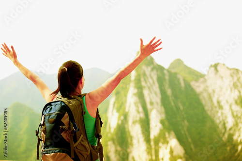Photo: woman hiker stand at peak of mountain huashan checking the map woman hiker stand at peak of mountain huashan checking the map