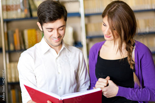 Photo: Students reading a book in a library Students reading a book in a library