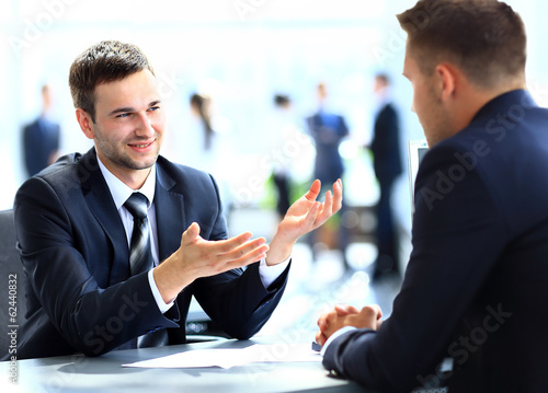 Photo: Happy business people talking on meeting at office Happy business people talking on meeting at office