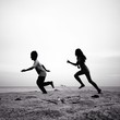 two kids running silhouettes running on the beach two kids running silhouettes running on the beach