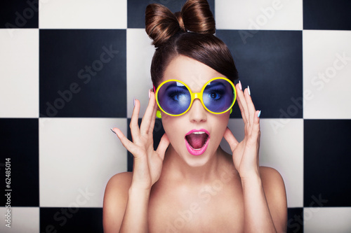 Photo: Attractive surprised young woman wearing sunglasses Attractive surprised young woman wearing sunglasses