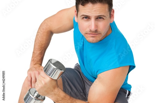 Photo: Portrait of a fit young man exercising with dumbbell Portrait of a fit young man exercising with dumbbell