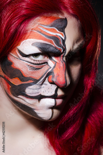 Photo: Woman with face painting in dark room Woman with face painting in dark room