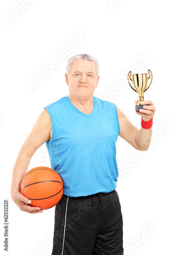 Photo: Mature athlete holding basketball and a trophy Mature athlete holding basketball and a trophy