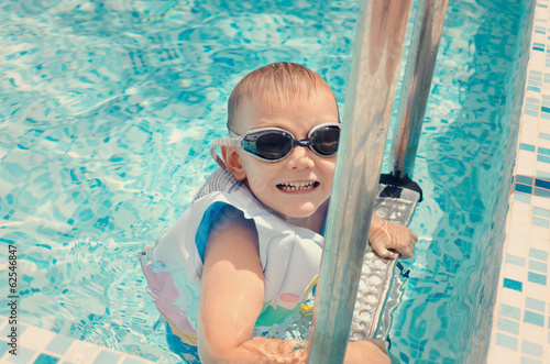 Photo: Laughing little boy climbing out of a pool Laughing little boy climbing out of a pool