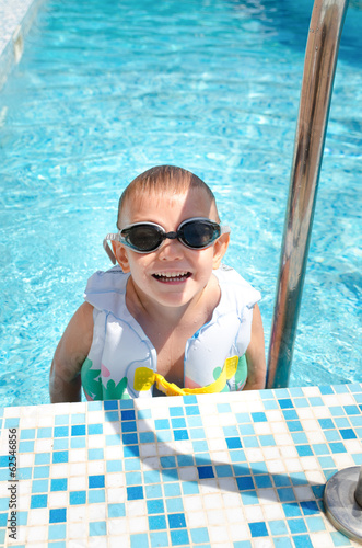 Photo: Laughing little boy climbing out of a pool Laughing little boy climbing out of a pool