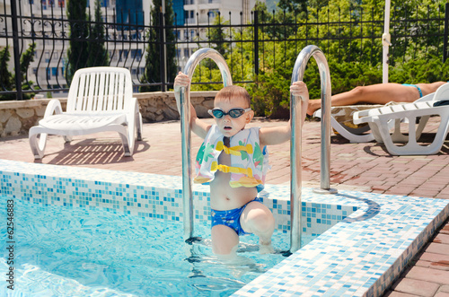 Photo: Small boy clambering out of a swimming pool Small boy clambering out of a swimming pool