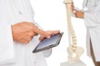 Mid section of doctors with digital table and skeleton model Mid section of doctors with digital table and skeleton model