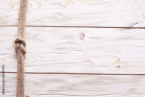 Photo: Sailor's knot over old wooden background. Sailor's knot over old wooden background.