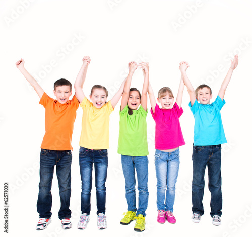 Photo: Group of smiling kids with raised hands. Group of smiling kids with raised hands.