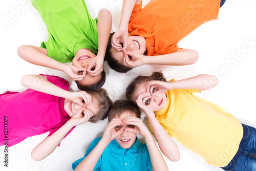 Photo: Five happy children lying on the floor in a circle. Five happy children lying on the floor in a circle.