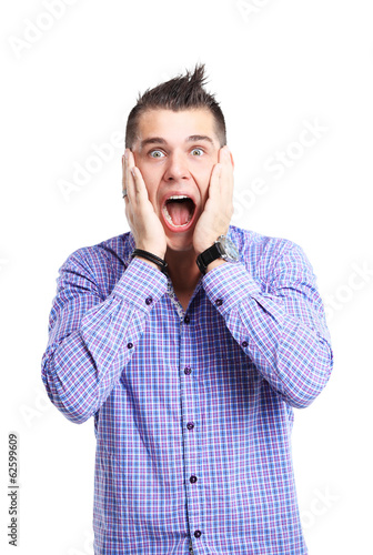 Photo: Portrait of young man with shocked facial expression Portrait of young man with shocked facial expression