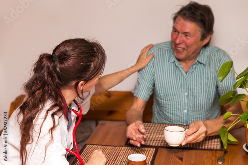 Photo: Altenpflegerin beim Kaffeetrinken mit Senior Altenpflegerin beim Kaffeetrinken mit Senior