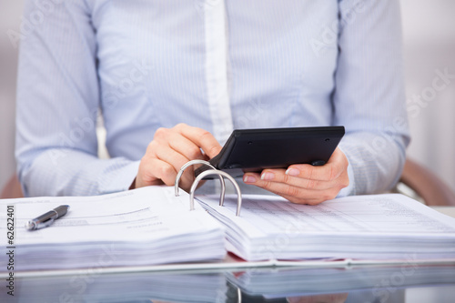 Photo: Businessperson Checking An Invoice In Office Businessperson Checking An Invoice In Office
