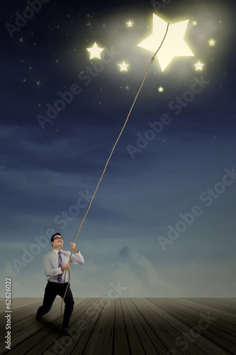 Photo: Businessman pulling stars Businessman pulling stars
