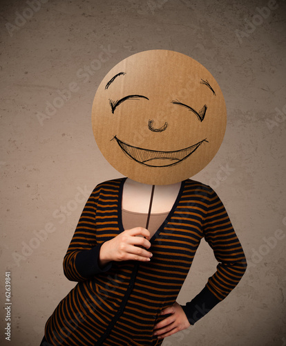 Photo: Young woman holding a smiley face board Young woman holding a smiley face board