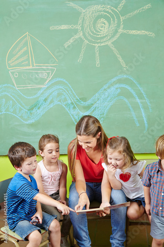 Photo: Kinder in Vorschule lesen Buch mit Erzieher Kinder in Vorschule lesen Buch mit Erzieher