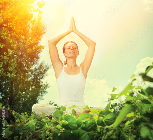 Photo: Young Woman doing Yoga Exercises Outdoor Young Woman doing Yoga Exercises Outdoor