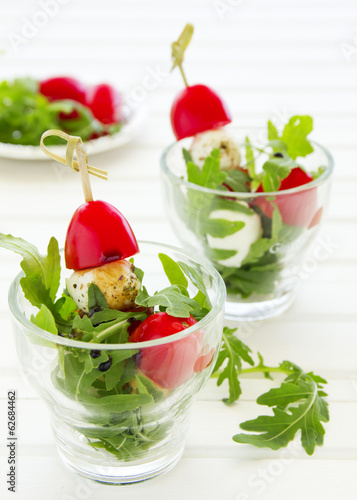 Photo: Salad with arugula, mozzarella and tomatoes. Salad with arugula, mozzarella and tomatoes.