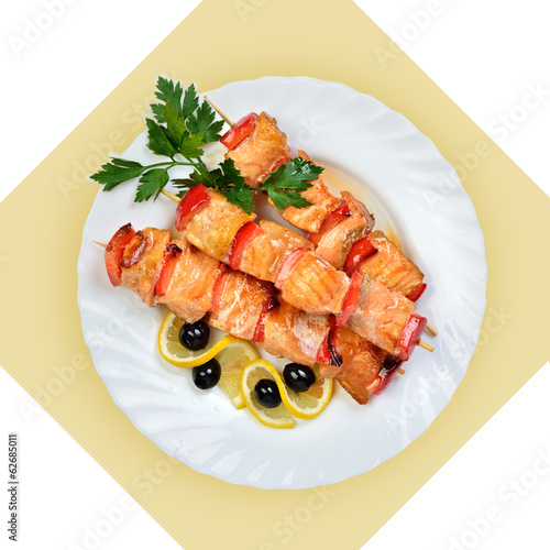 Photo: Dish of salmon fish on skewer on white plate. Dish of salmon fish on skewer on white plate.