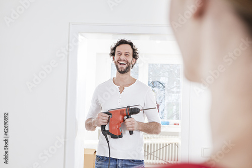 Photo: Mann hält Bohrer Mann hält Bohrer