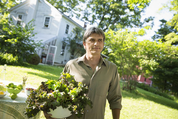 Photo: On The Farm. A Man In A Farmhouse Garden, Carrying A Large Bowl Of Freshly Picked Organic Lettuce And Salad Leaves. On The Farm. A Man In A Farmhouse Garden, Carrying A Large Bowl Of Freshly Picked Organic Lettuce And Salad Leaves.