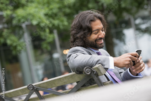 Foto: Business People. A Man In A Business Suit With A Full Beard And Curly Hair. Using His Phone. Business People. A Man In A Business Suit With A Full Beard And Curly Hair. Using His Phone.