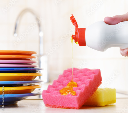 Photo: Several plates and a kitchen sponge. Dishwashing concept Several plates and a kitchen sponge. Dishwashing concept