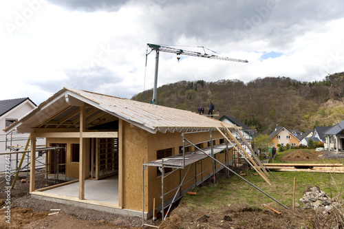 Photo: Deutschland, Rheinland-Pfalz, Arbeiter platzieren Dach auf Haus Deutschland, Rheinland-Pfalz, Arbeiter platzieren Dach auf Haus