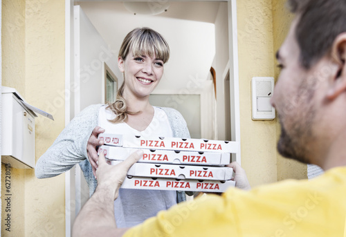 Photo: Deutschland, Köln, Junge Frau, die Pizza-Kartons aus Lieferung Mann Deutschland, Köln, Junge Frau, die Pizza-Kartons aus Lieferung Mann