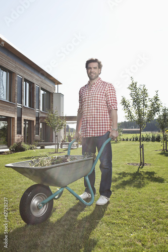Photo: Deutschland, Nürnberg, Mann mit Schubkarre im Garten Deutschland, Nürnberg, Mann mit Schubkarre im Garten