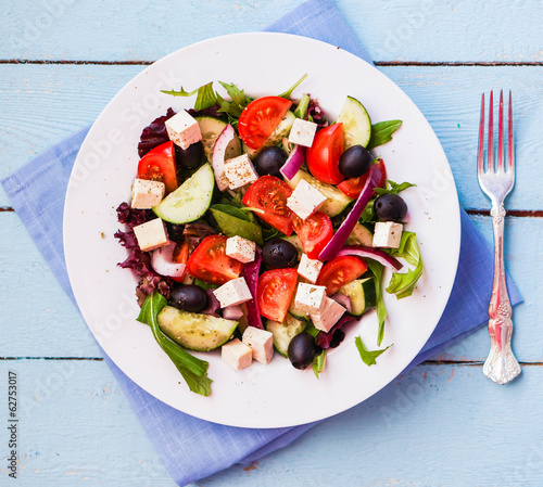 Photo: Greek salad on wooden background Greek salad on wooden background