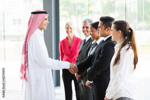 Photo: Arabian businessman handshaking with his employees Arabian businessman handshaking with his employees