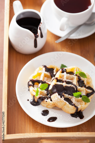 Photo: Belgian waffles with chocolate and powder sugar for breakfast Belgian waffles with chocolate and powder sugar for breakfast
