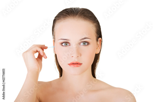 Photo: Woman cleans her ear Woman cleans her ear