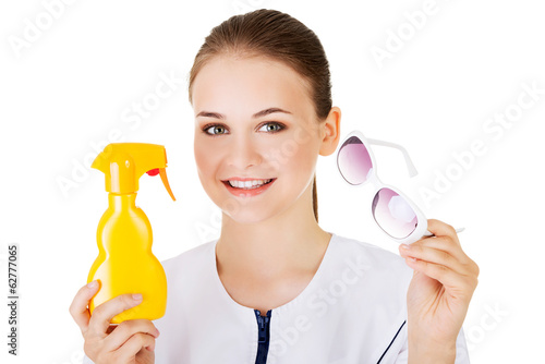 Photo: Doctor showing sunscreen and sun glasses. Doctor showing sunscreen and sun glasses.