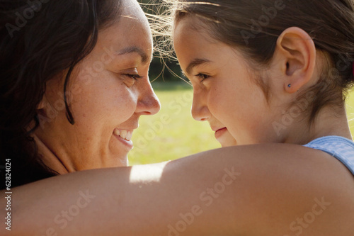 Photo: A mother and daughter embracing, an adult and child. A mother and daughter embracing, an adult and child.