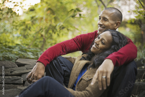 Foto: Scenes from urban life in New York City. A man and a woman, a couple sitting close together under the trees. Scenes from urban life in New York City. A man and a woman, a couple sitting close together under the trees.