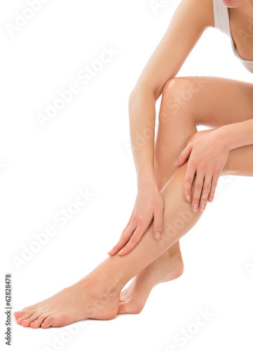 Photo: Woman touching hands and legs with french manicured nails Woman touching hands and legs with french manicured nails