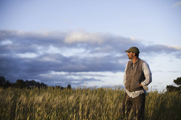Photo: A man standing looking over the crops and fields at the Homeless Garden Project in Santa Cruz, at sunset. A man standing looking over the crops and fields at the Homeless Garden Project in Santa Cruz, at sunset.