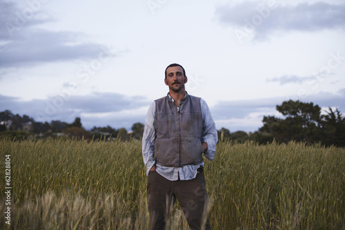 Photo: A man standing by a field of growing cereal crop, at the social care and work project, the Homeless Garden Project in Santa Cruz. A man standing by a field of growing cereal crop, at the social care and work project, the Homeless Garden Project in Santa Cruz.