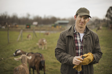 Photo: A small organic dairy farm with a mixed herd of cows and goats. Farmer working and tending to the animals. A small organic dairy farm with a mixed herd of cows and goats. Farmer working and tending to the animals.